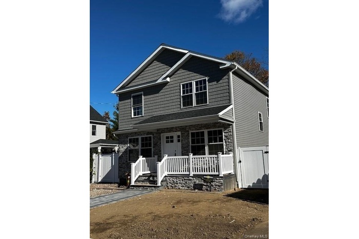 View of front facade featuring a gate, stone siding, and a porch