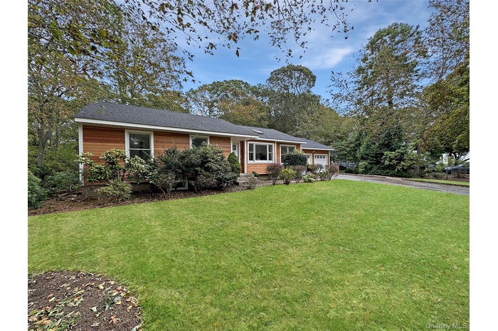 Ranch-style house with a front yard, driveway, and an attached garage