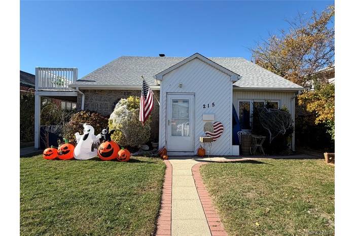 View of front facade with a new shingled roof, side deck 4 caar driveway, and  front lawn