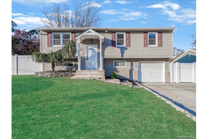 Split foyer home featuring an attached garage and concrete driveway