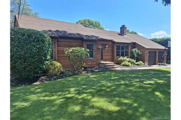 Rustic home with a front yard, a chimney, a garage, and a shingled roof
