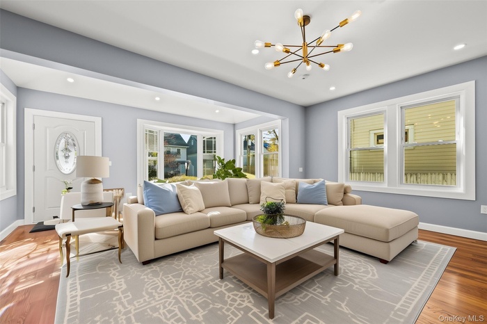 Living area featuring wood finished floors, a chandelier, and recessed lighting