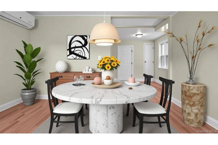 Dining space featuring light wood finished floors and a wall unit AC