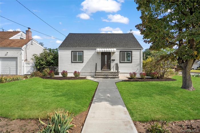 View of front of property with a front lawn and roof with shingles