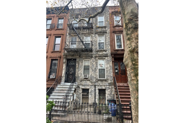 View of front of property featuring a fenced front yard and stone siding