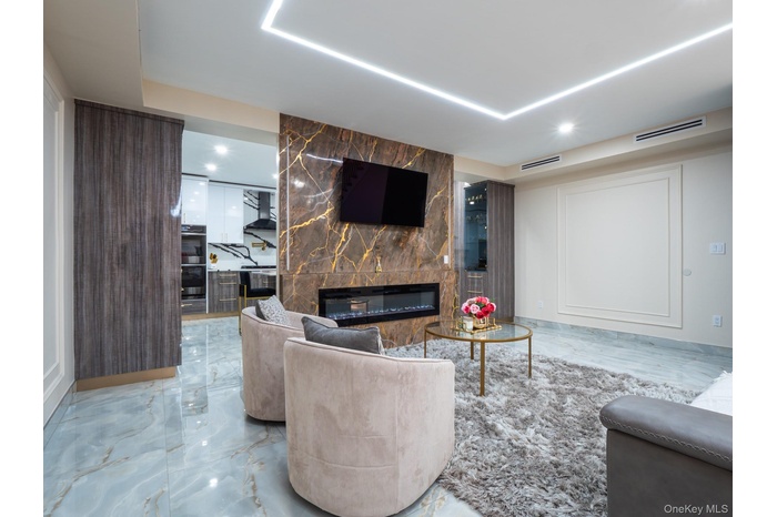 Living room with marble tiled floors, a tile fireplace, and recessed lighting