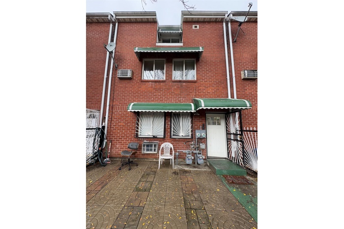 Rear view of property with brick siding