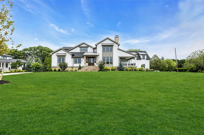 View of front of house featuring a chimney and a front yard