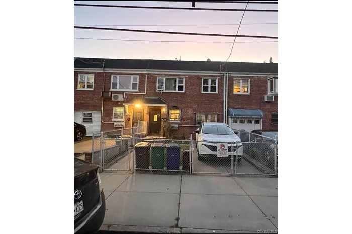 Traditional-style house featuring a gate, brick siding, a fenced front yard, and a garage