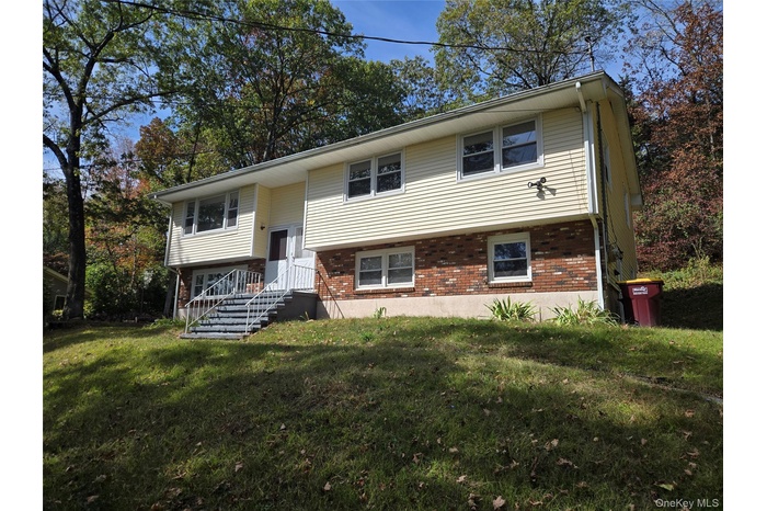 Bi-level home with a front yard and brick siding