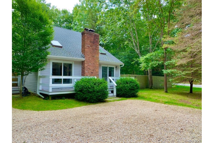 View of side of home featuring a shingled roof and a chimney