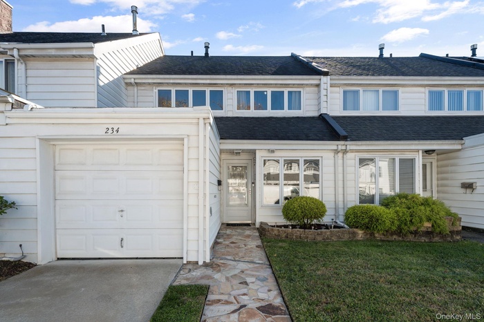 Traditional-style home featuring roof with shingles and a front yard