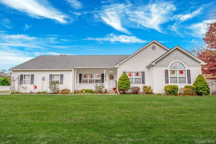 View of front of property with covered porch, a front yard, and roof with shingles