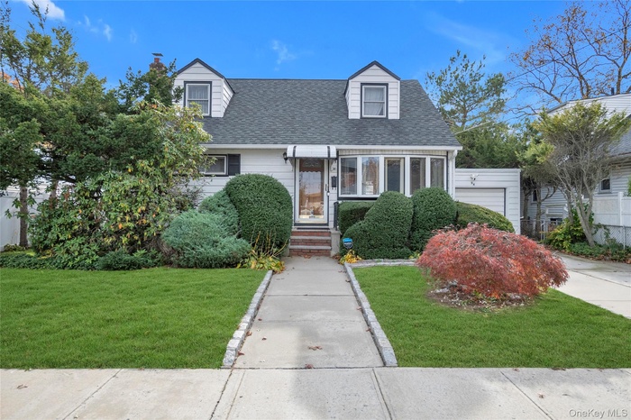 New england style home with roof with shingles and a chimney