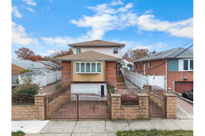View of front facade with a gate, a fenced front yard, and brick siding