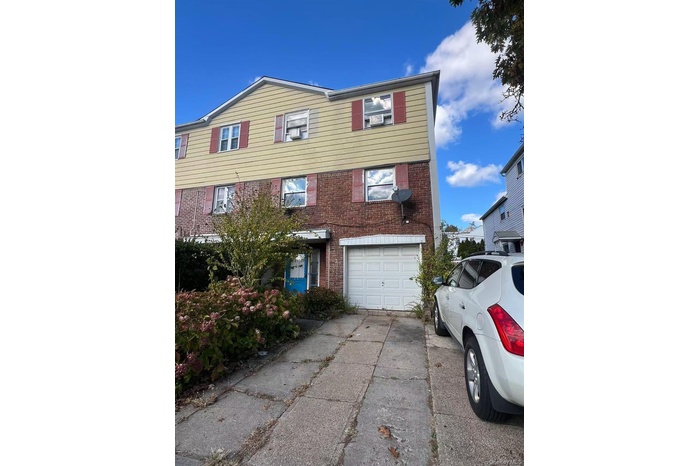 View of front of property with an attached garage, brick siding, and concrete driveway