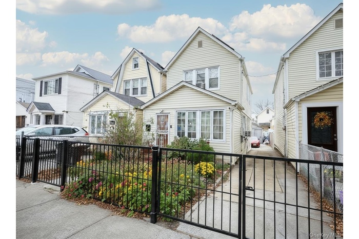 View of front of house featuring a residential view, a fenced front yard, and a gate