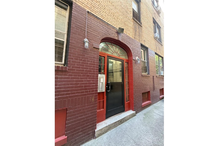 View of exterior entry featuring brick siding and cooling unit