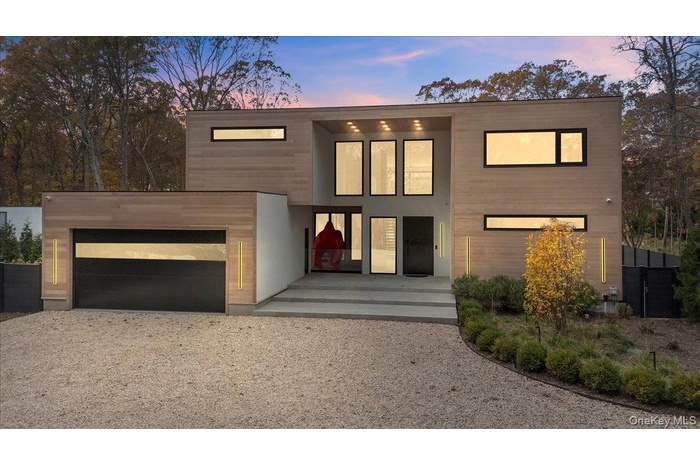 Contemporary home featuring gravel driveway and an attached garage