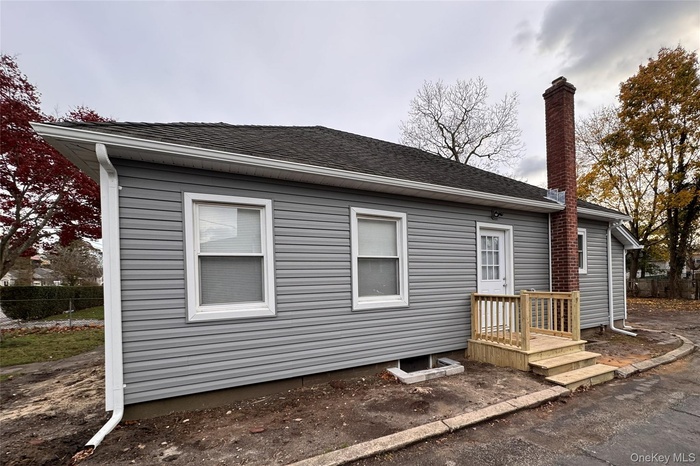 View of side of home featuring a chimney and roof with shingles