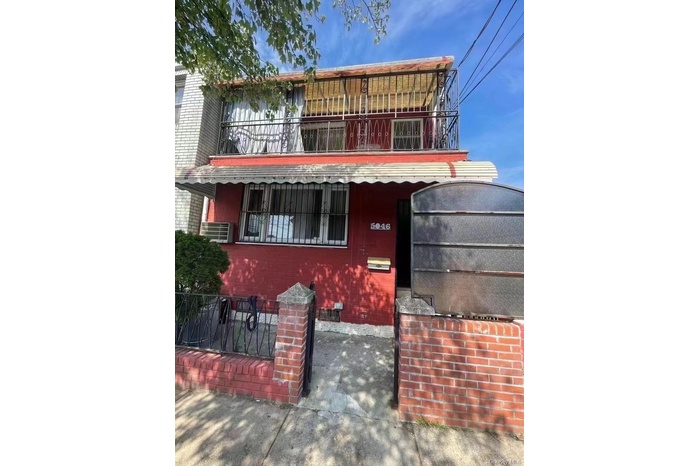 View of front facade featuring a balcony and brick siding