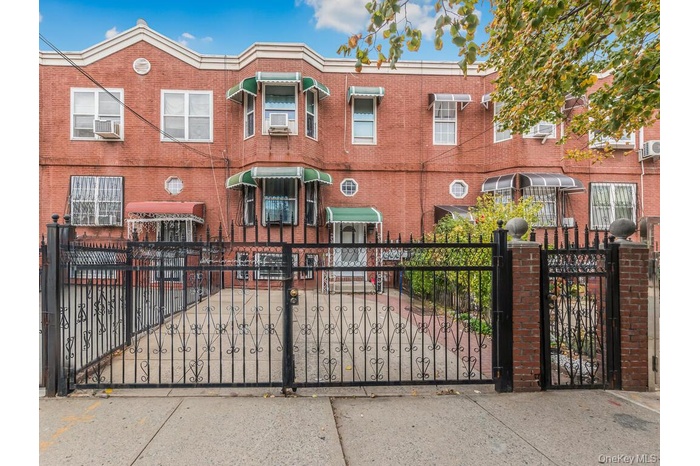 View of front of home featuring a fenced front yard, a gate, and brick siding