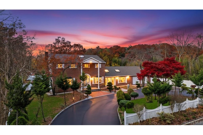 Greek revival inspired property featuring asphalt driveway