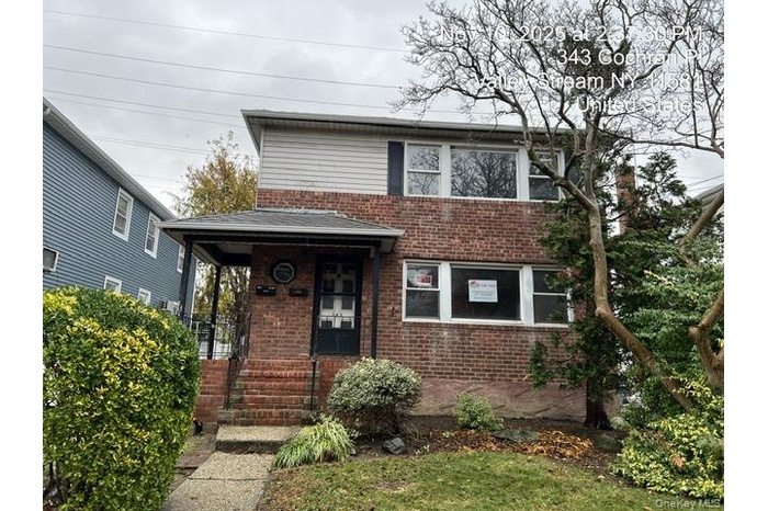 View of front of home featuring brick siding and covered porch