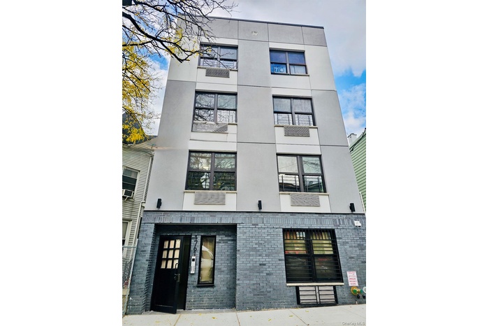 View of apartment building / complex featuring cooling unit