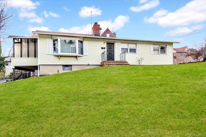Single story home with a chimney and a front lawn