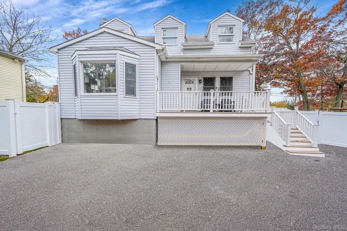 View of front facade with a gate, covered porch, and stairs