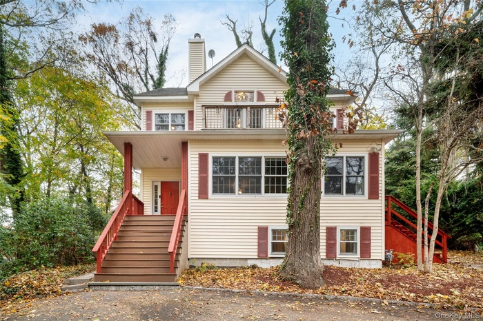 View of front of house featuring stairs and a chimney
