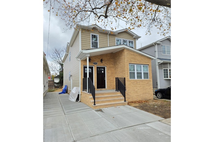 View of front of home featuring brick siding and covered porch