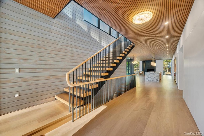 Staircase with wooden walls, wood ceiling, wood finished floors, and an outdoor fireplace