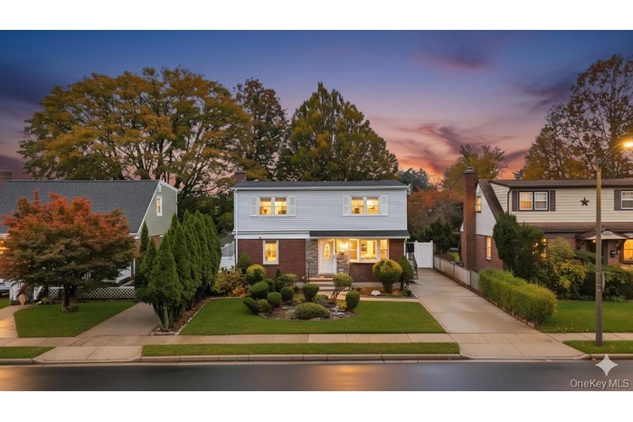 View of front of home featuring brick siding and a chimney