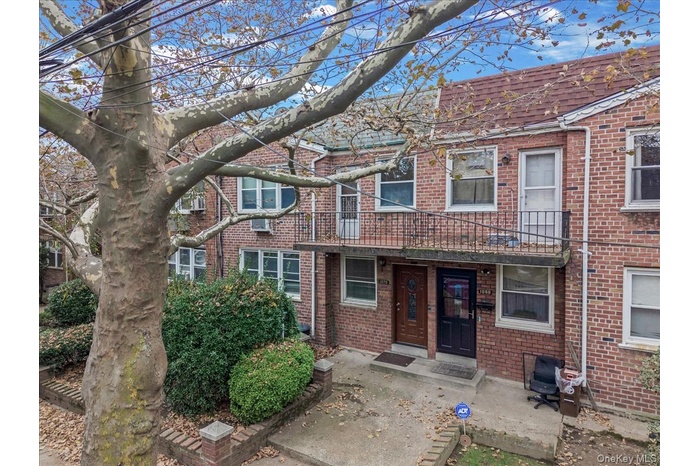 View of front of house featuring brick siding and a balcony