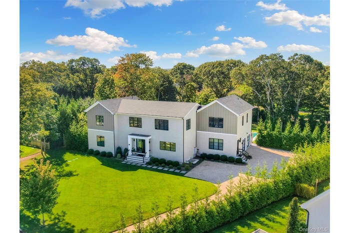 View of front of house featuring a front yard, board and batten siding, and a wooded view