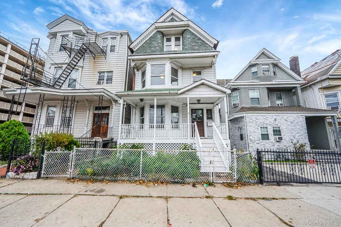 Victorian home featuring a gate, a porch, a fenced front yard, and stairway