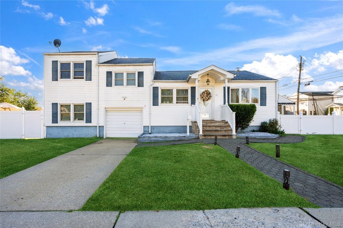 View of front of home featuring driveway, a garage, and a shingled roof