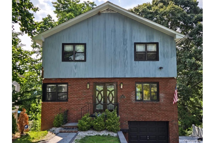 Welcome Home to 17 Arthur Place, in Northern Yonkers, NY. View of front of home featuring a garage and brick siding