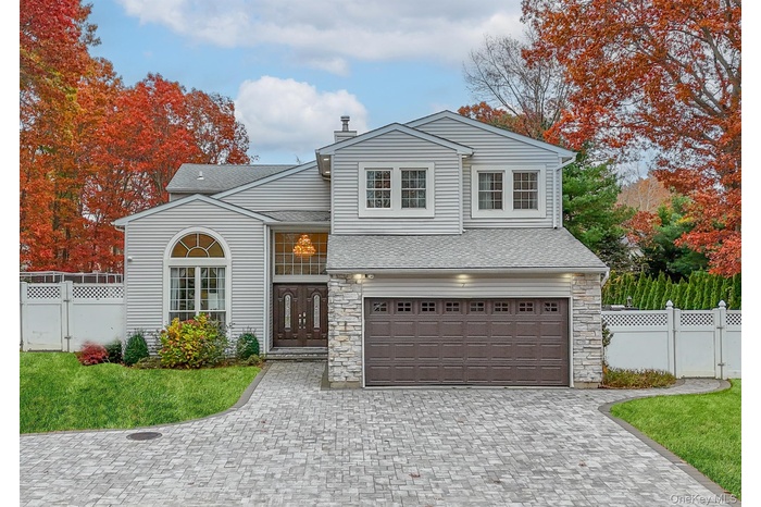 View of front of house featuring a gate, decorative driveway, and stone siding