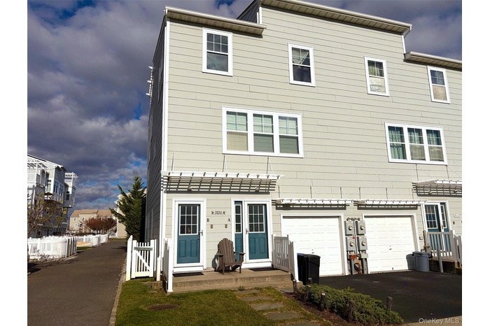 Back of house featuring an attached garage and driveway