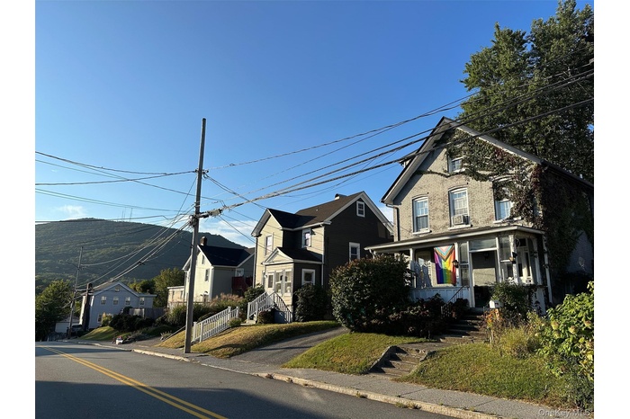 View of front of house featuring covered porch, a residential view, and brick siding