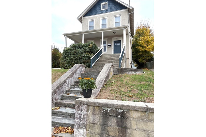 American foursquare style home with stairway, stucco siding, and a porch