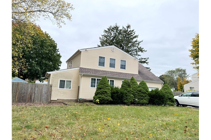 View of side of property with a shingled roof