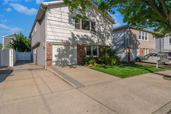 View of front of home featuring brick siding, driveway, and a garage