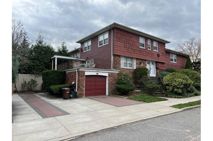 View of front of house featuring concrete driveway, a garage, and brick siding