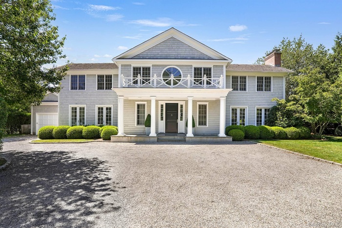 View of front of home featuring a porch, a chimney, and driveway