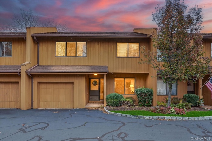 View of front of house with an attached garage and roof with shingles