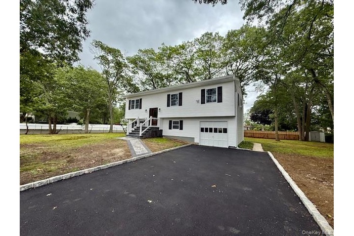 Split foyer home with asphalt driveway and a garage
